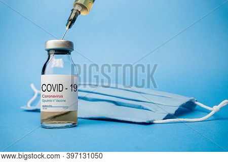 Sputnik V Vaccine Concept And Background For Coronavirus. New Vaccine Sputnik-v Isolated On Blue Bac
