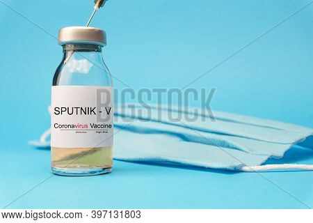 Sputnik V Vaccine Concept And Background For Coronavirus. New Vaccine Sputnik-v Isolated On Blue Bac