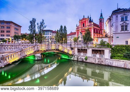 Ljubljana City Center At Dusk Overlooking The Triple Bridge And Beautiful Franciscan Church, Sloveni