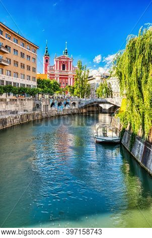 Ljubljana City Center During A Sunny Day Overlooking Lublanka River And Beautiful Franciscan Church,