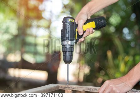 Skilled Professional Carpenter In Workwear Using Electric Drill Machine, Custom Woodworking, Making 