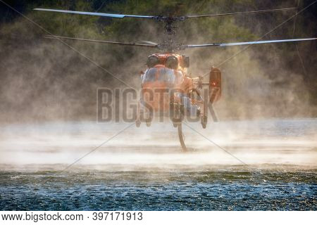 Ka-32 Firefighting Helicopter Is Hovering Over The Pond To Refills Water