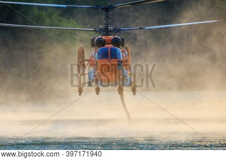 Ka-32 Firefighting Helicopter Is Hovering Over The Pond To Refills Water