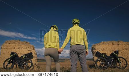 The Man And Woman Travel On Mixed Terrain Cycle Touring With Bikepacking. The Two People Journey Wit