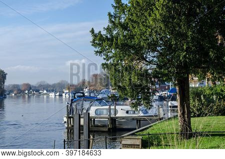 Boats Moored Along The Banks Of The River Thames On A Sunny Autumn Day In Bourne End, Buckinghamshir