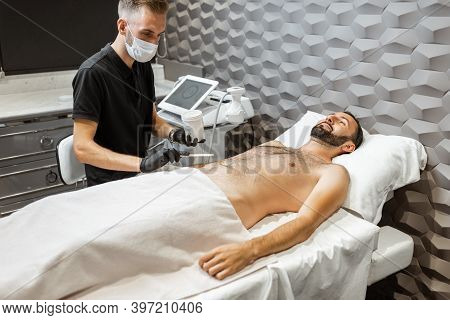 Man With A Doctor At Luxury Spa Salon. Preparation For Liposuction Procedure