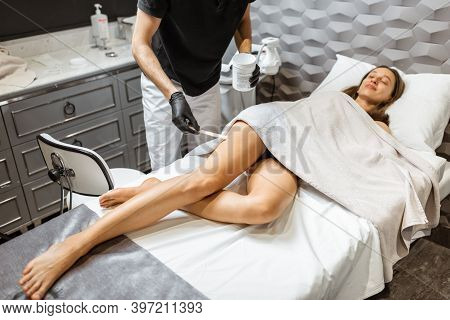 Young Woman During An Ultrasound Liposuction Procedure At Luxury Spa Salon. Doctor Working On Thigh 