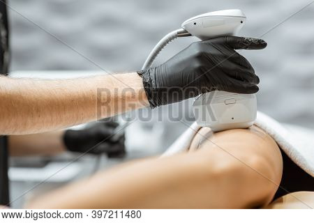 Young Woman During An Ultrasound Liposuction Procedure At Luxury Spa Salon. Doctor Working On Thigh 