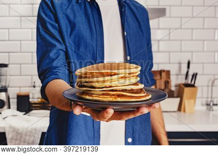 Man Holds A Stack Of Fresh Baked Pankes