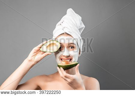 Portrait Of A Young Woman Applying Natural Avocado Mask On Her Face. Face Skin Care. Cleansing Proce