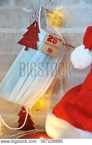 Celebrated Christmas With Face Mask Concept. Blue Face Mask Hanging With Paper Tag On Christmas Date