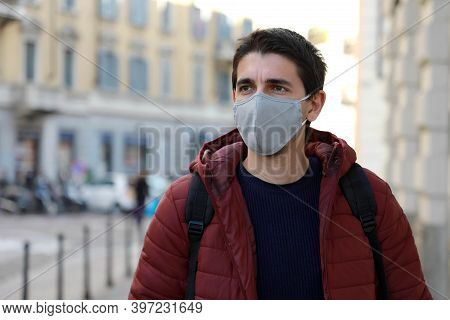Young Man Wearing Face Mask Walking Down The Street Looking To The Side