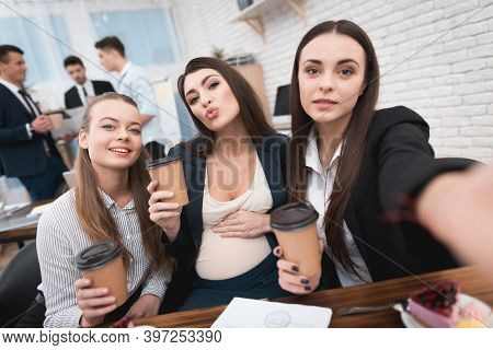 Two Young Girls Are Laughing At Work Annoying Boss. Two Women Are Standing In The Office With Papers