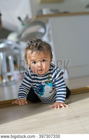 Cute 8-month-old baby girl crowling on all four