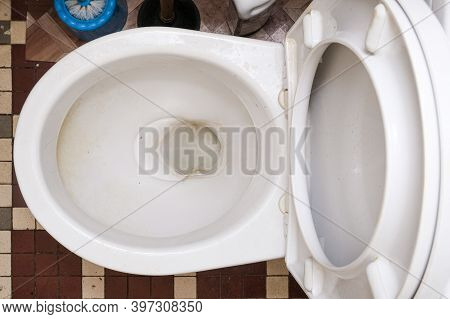 Dirty Unhygienic Toilet Bowl With Limescale Stain At Public Restroom, Top View.