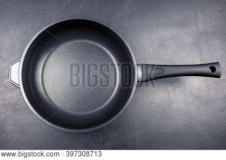 Biack Frying Pan With Non-stick Teflon Coating On Dark Background