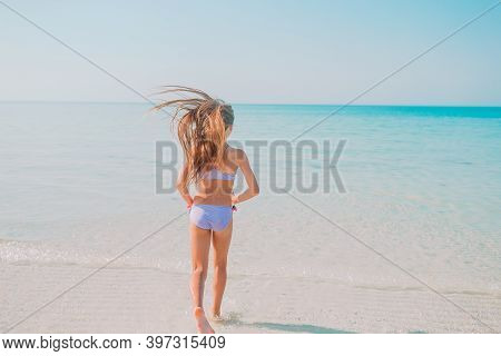 Adorable Active Little Girl At Beach During Summer Vacation