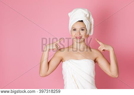Mock Up A Young Smiling Woman In A Towel Points Her Index Fingers At Her Happy Face Isolated On A Pi