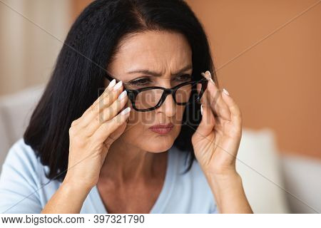 Poor Eyesight Concept. Closeup Portrait Of Mature Woman Squinting, Trying To Look Closer Through Eye