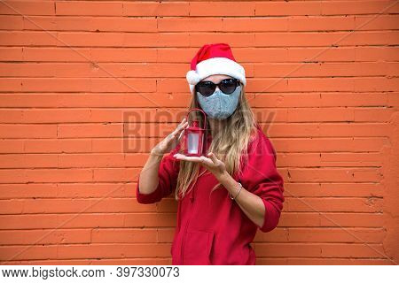 Blond Girl In Silver Mask, Red Hat And Black Sun Glasses Holds In Hands Christmas Light. Caucasian W