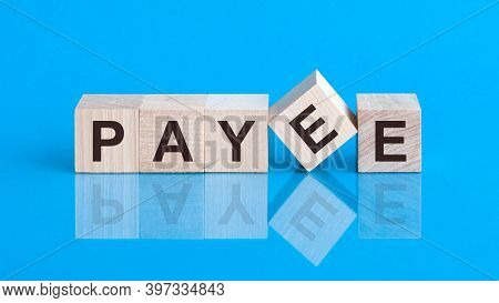 The Text Payee Is Written On The Cubes In Black Letters, The Cubes Are Located On A Blue Glass Surfa