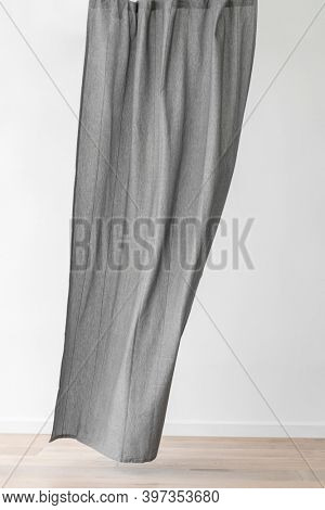 Gray drapery hanging from a curtain rod