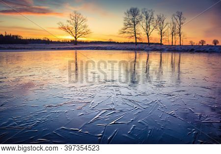 A Beautiful Frozen Pond In The Rural Scene During The Morning Golden Hour. A Winter Scenery Of North