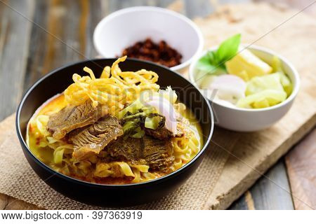 Northern Thai Food (khao Soi), Spicy Curry Noodles Soup With Beef In A Bowl Eating With Crispy Deep-
