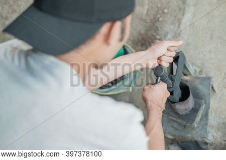 Close Up Of Tire Patcher Rotates The Handle Of A Traditional Press Before Patching The Inner Tube