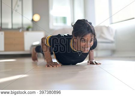 Athletic african-american woman doing fitness exercices at home