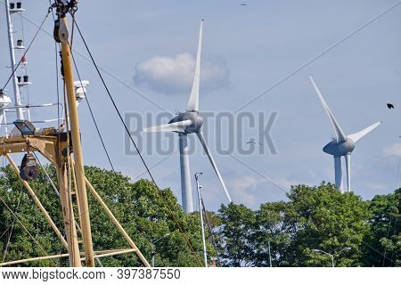 Urk, The Netherlands - June 15 2020 Windmills On The Coast With Trees, Mast And Birds Moving. Wind P