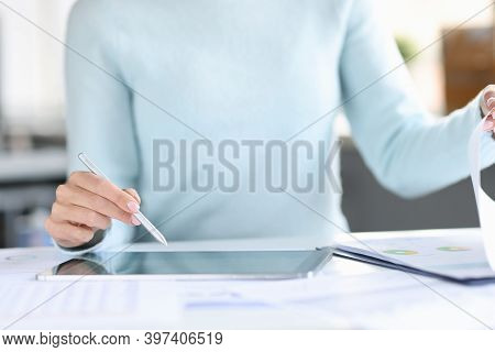 Woman Holding Stylus With Her Hand Over A Tablet And Turning Page In Documents Closeup. Conducting B