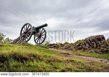 Checiny, Poland - September 06, 2020: Historic Cannon In Front Of Prison Tower And Eastern Gate Of R