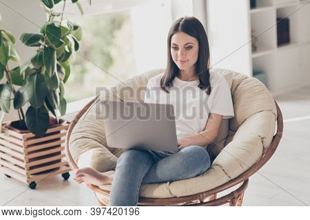 Photo Of Smart Girl Sit Wicker Armchair Work Laptop Wear White T-shirt Denim Jeans In House Indoors