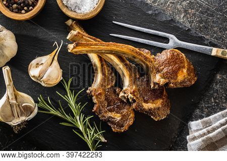 Grilled lamb chops on stone cutting board. Top view.