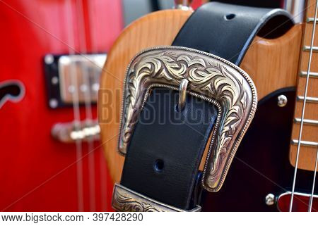 Electric Guitars And Leather Strap With Silver Buckle Close-up.