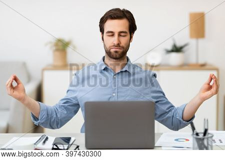 Keep Calm. Businessman Meditating In Office, Sitting At Laptop With Eyes Closed Relaxing For Work St