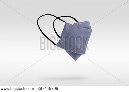 Light purplish-blue fabric face mask on gray background