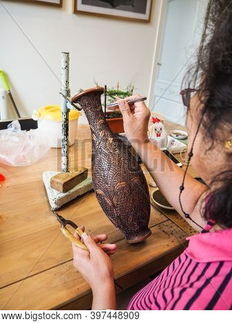 Woman Gluing Tiny Shaped Cloisonne Wires To A Copper Vase Creating A Intricately Constructed Pattern