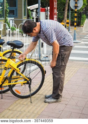Beijing, China - September 2017: Man Using Smartphone To Scan The Qr Code And Unlock A Bike From The