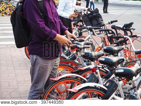 Beijing, China - September 2017: Men Using Smartphones To Scan The Qr Code And Unlock A Bike From Th