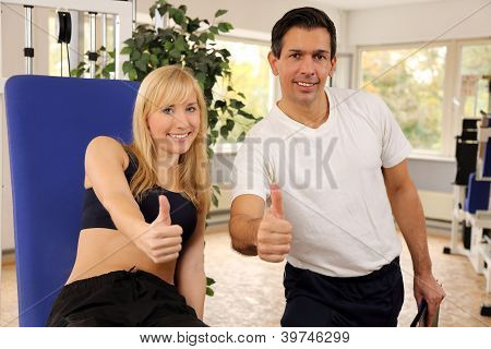 attraktive blonde Frau und ihr Trainer in einem Fitnessstudio