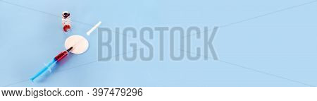 Glass Vials And Used Syringes On Blue Background For Banner. One Syringe Contains Medicine With A Sh