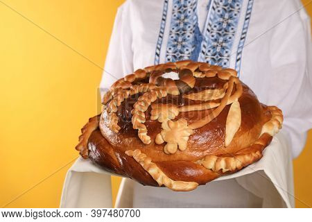 Woman With Korovai On Yellow Background, Closeup. Ukrainian Bread And Salt Welcoming Tradition