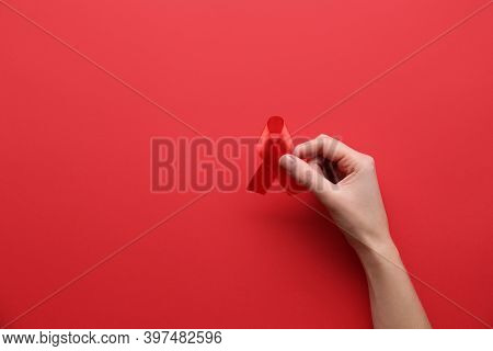 Woman Holding Red Awareness Ribbon On Color Background, Top View With Space For Text. World Aids Dis