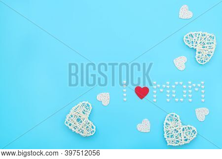 The Text I Love Mom Made Of Small Pearl Hearts With Red Felt Heart And Rattan, Felt Hearts On Blue B