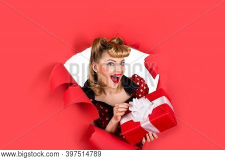 Pin Up Girl With Gift. Breaking Paper. Surprised Retro Woman Hold Gift Box Through Hole In Paper. Wo
