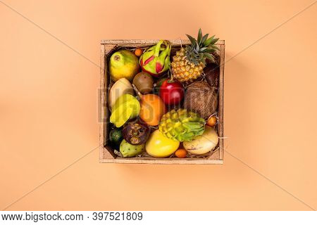 Fresh Exptic Fruits In Wooden Box Top View. Fruit Dragon, Papaya, Maracuya, Kiwi, Mango And Granadil