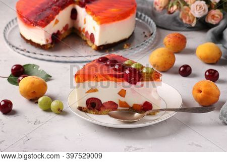 Homemade Jelly Cake With Berries On Gray Background And Slice Cake On A Plate On Foreground. Horizon