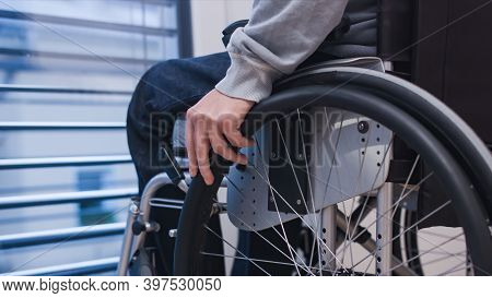 Man On Wheelchair In Living Room Looking Through Window. Handicapped  Paralysed Person, Depre